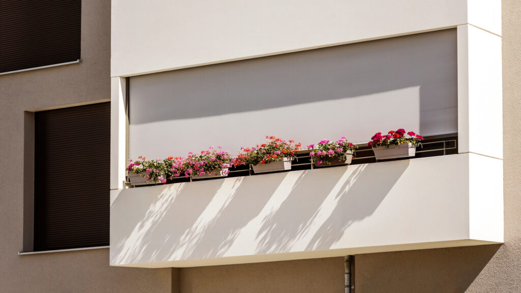 Balcony with Flowers and External Shutters. Modern Decorated Balcony with Blinds on Facade. Balconies Roller Blinds.